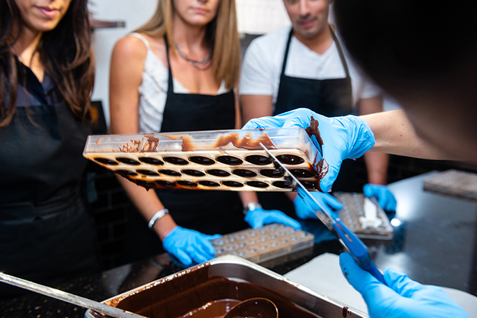Démonstration de la réalisation de coques en chocolats du chef lors d'un atelier collectif.